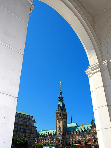 Foto Blick durch die Bögen der Alster Arkaden auf das Rathaus